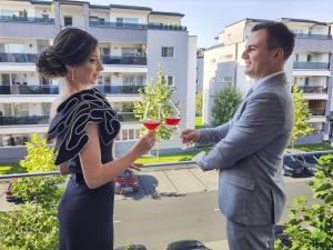 a man and a woman holding glasses of wine at Exclusive Apartment SIBIU in Sibiu