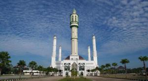 ein weißes Gebäude mit einem Turm darüber in der Unterkunft OYO 93306 Homestay Permana Supadio Airport in Pontianak