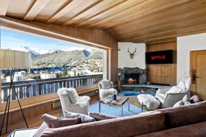 sala de estar con sofá y ventana grande en A&Y Chalet zum goldenen Hirsch, en Davos