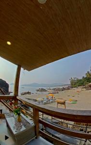 Blick auf den Strand mit einem Holztisch in der Unterkunft Pacific Sunset View Palolem in Palolem