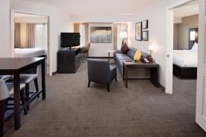 een hotelkamer met een bank, een bed en een bureau bij Residence Inn Arlington in Arlington