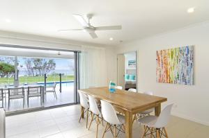 una sala da pranzo con tavolo e sedie in legno di Sentosa on Tugun - Beachfront 5 Bedroom a Gold Coast