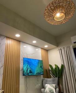 een woonkamer met een flatscreen-tv aan de muur bij Alpine Villas Greens Staycation at Crosswinds Tagaytay in Tagaytay