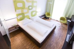 um quarto com uma cama branca e uma parede verde em arte Hotel Krems em Krems an der Donau