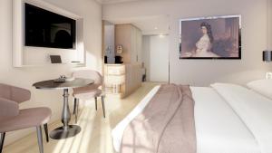 a white room with a bed and a table in it at Grand Elisabeth - Grand Opening April 2025 in Bad Ischl