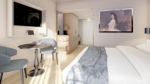 a bedroom with a bed and a table and chairs at Grand Elisabeth - Grand Opening April 2025 in Bad Ischl