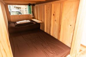 福岡市にあるFukuoka Guesthouse CAMPの木造キャビン内のベッド1台が備わる小さな客室です。