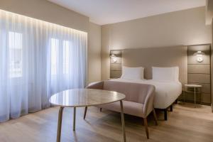 a hotel room with a bed and a table at AC Hotel Carlton Madrid by Marriott in Madrid