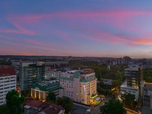 uitzicht op de stad bij zonsondergang met gebouwen bij Radisson Blu Leogrand Hotel in Chişinău