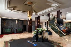 een lobby met een trap in een gebouw bij Radisson Blu Leogrand Hotel in Chişinău