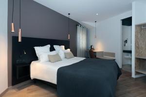 a bedroom with a large bed with white pillows at Le Néliö in Aix-en-Provence