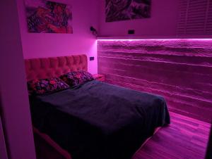 een slaapkamer met een bed met roze verlichting bij Panoramic view home in Kaunas