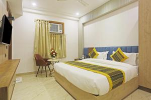 a bedroom with a bed and a desk and a television at Hotel Mehul Int-New Delhi in New Delhi