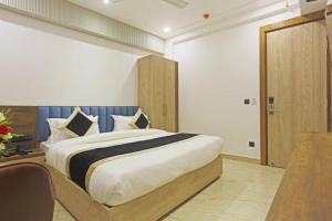 a bedroom with a large bed with a wooden headboard at Hotel Mehul Int-New Delhi in New Delhi