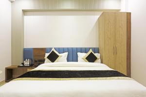 a bedroom with a large bed with a blue headboard at Hotel Mehul Int-New Delhi in New Delhi