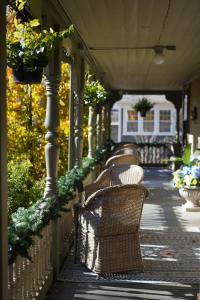 - une rangée de chaises en osier assises sur une terrasse couverte dans l'établissement The Underwood-Hale House, à Providence