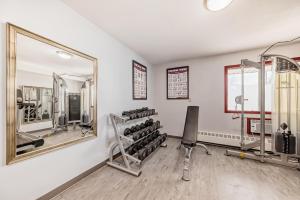 een fitnessruimte met spiegels en een stoel bij Stony Plain Inn & Suites in Stony Plain