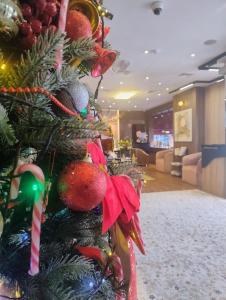 Un albero di Natale con sopra degli ornamenti in una hall di AG Hotel a Abu Dhabi