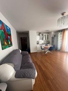 uma sala de estar com um sofá e uma sala de jantar em Warsaw Oxygen Apartment em Varósvia