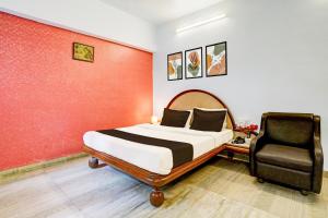 - une chambre avec un lit et une chaise dans l'établissement Super Hotel O Padampura Near Railway Station formerly Shree Maya, à Aurangabad