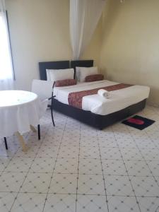 een slaapkamer met 2 bedden en een tafel. bij Mirok Gardens Kisumu in Kisumu