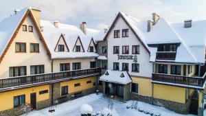 a group of buildings with snow on the roofs at DW Janosik in Muszyna