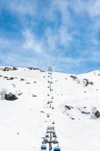 a snow covered hill with a row of ski lifts at Glacier Rock guesthouse in Solda