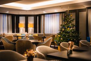 a christmas tree in a restaurant with tables and chairs at Hilton Vienna Plaza in Vienna