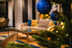 a living room with a couch and a christmas tree at Hilton Vienna Plaza in Vienna