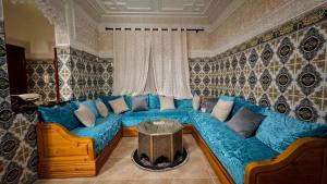 ein Wohnzimmer mit einem blauen Sofa und einem Tisch in der Unterkunft Appartement near to AirPort 262 avenue el khalij 2 BEDROOM in Marrakesch