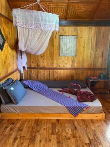 a bed in a wooden room with a net at Sapa Orange Homestay in Sa Pa