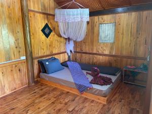 a small bed in a room with wooden walls at Sapa Orange Homestay in Sa Pa