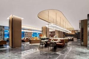 un restaurante con mesas y sillas en Wyndham Grand Plaza Royale Lugu Changsha, en Changsha