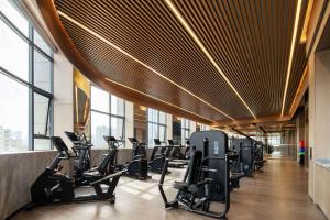 un gimnasio con filas de cintas de correr y máquinas elípticas en Wyndham Grand Plaza Royale Lugu Changsha, en Changsha