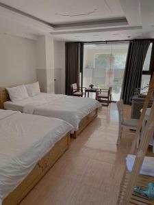 een hotelkamer met 2 bedden en een eetkamer bij Hotel Rocket in Vung Tau