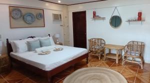 um quarto com uma cama, uma mesa e cadeiras em Kerusso Haven em Puerto Princesa