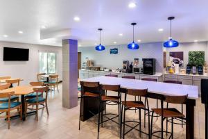 un ristorante con bar con luci blu di Clarion Pointe a Fort Worth