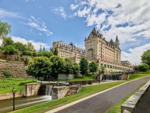 ein großes Gebäude mit einem Fluss davor in der Unterkunft Fairmont Chateau Laurier in Ottawa