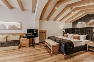 Schlafzimmer mit einem Bett und einem Flachbild-TV in der Unterkunft Freina Mountain Lifestyle Hotel in Wolkenstein in Gröden