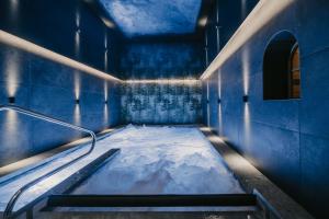 a blue room with a tub with snow in it at Freina Mountain Lifestyle Hotel in Selva di Val Gardena