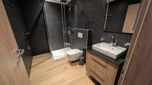 a bathroom with a toilet and a sink and a shower at Le Belvedere By Alaïa in Crans-Montana