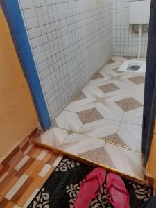 a pair of red shoes on the floor of a bathroom at EUGENE HOMES Guest House in Gilgil