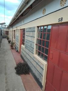 a building with red and blue doors on it at EUGENE HOMES Guest House in Gilgil