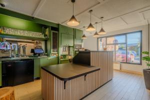 a kitchen with green cabinets and a black island in it at Campanile Lille Est - Villeneuve D'ascq in Villeneuve d'Ascq