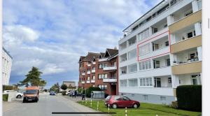 un coche rojo estacionado frente a un edificio en Direkt am Strand in Scharbeutz, en Scharbeutz