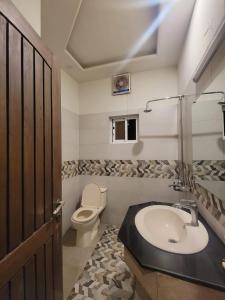 uma casa de banho com um lavatório e um WC. em Dream Inn Guest House em Islamabad