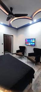 uma sala de reuniões com cadeiras e uma televisão de ecrã plano em Dream Inn Guest House em Islamabad