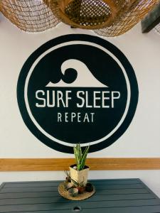 een bord op een muur met een plant op een tafel bij Surf&Sleep in Corralejo