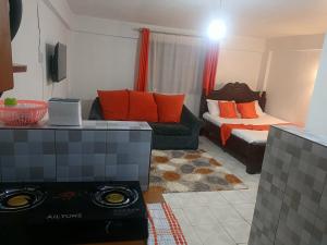 a living room with a couch and a bed at Befil in Meru