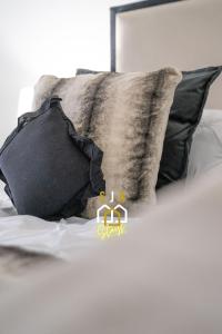 a bed with black and gray pillows on it at Panacotta House - SJA Stays - Modern 1 Bed Apartment in Aberdeen